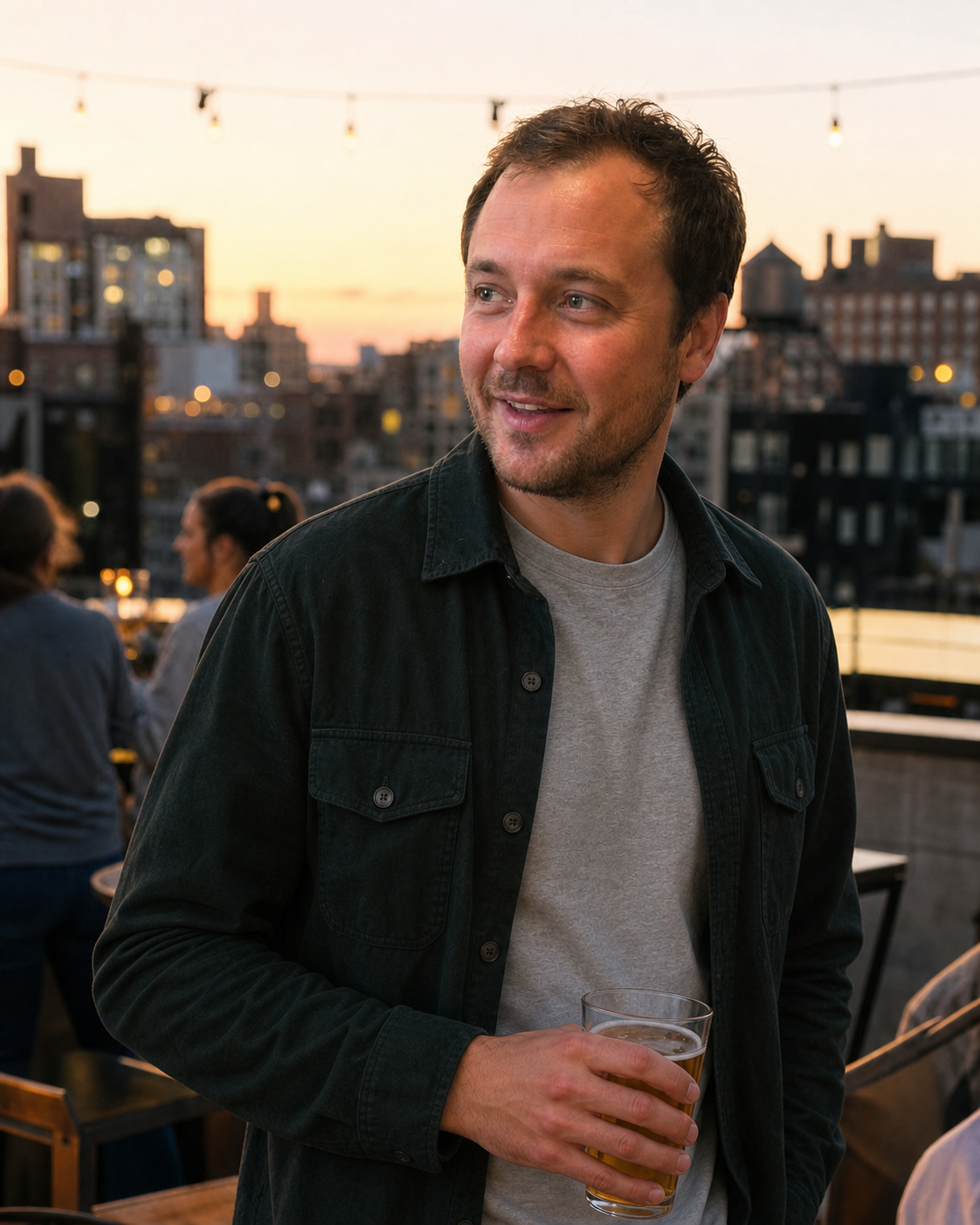 The same man from the hero shown in a natural rooftop drinks profile photo